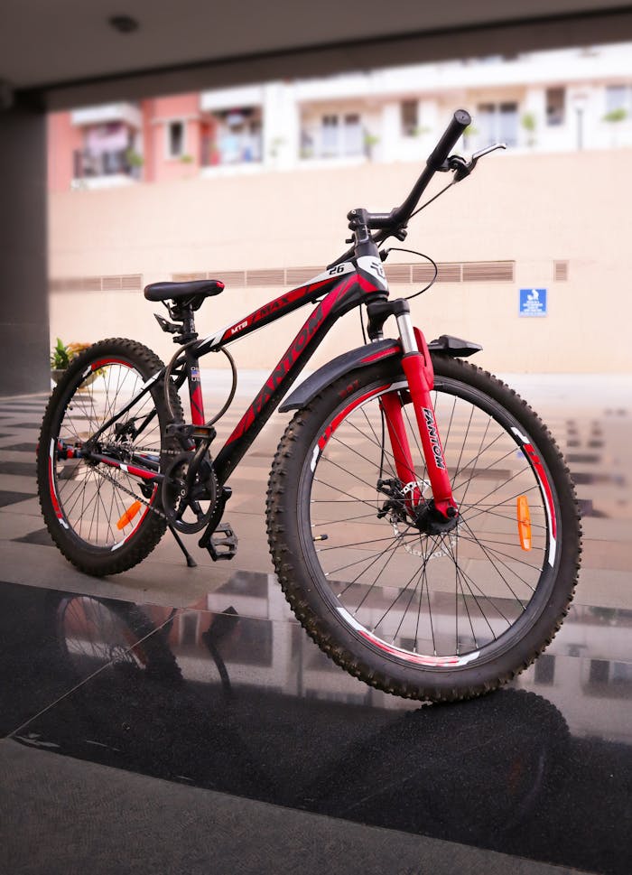 A modern red and black mountain bike parked indoors showcasing its sturdy frame and design.